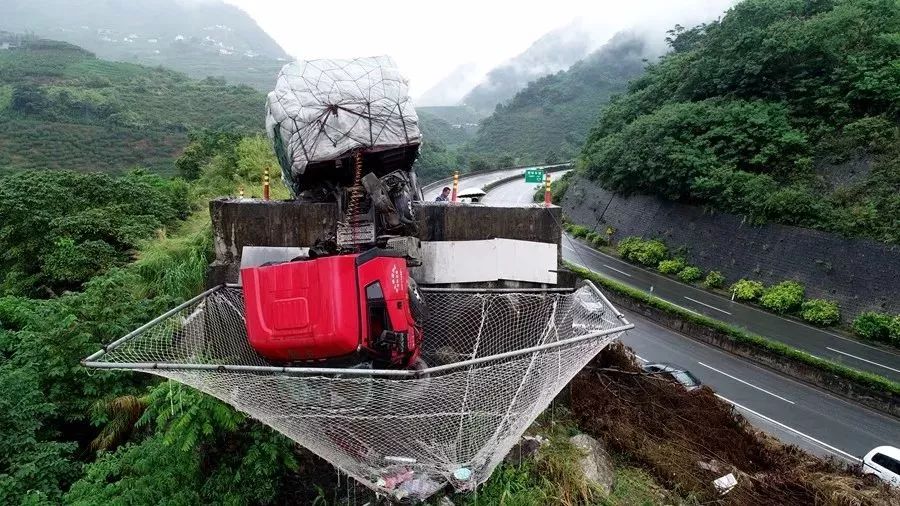 重型卡车在悬崖上掉头,卡车坠落悬崖被一个大巨石卡住了