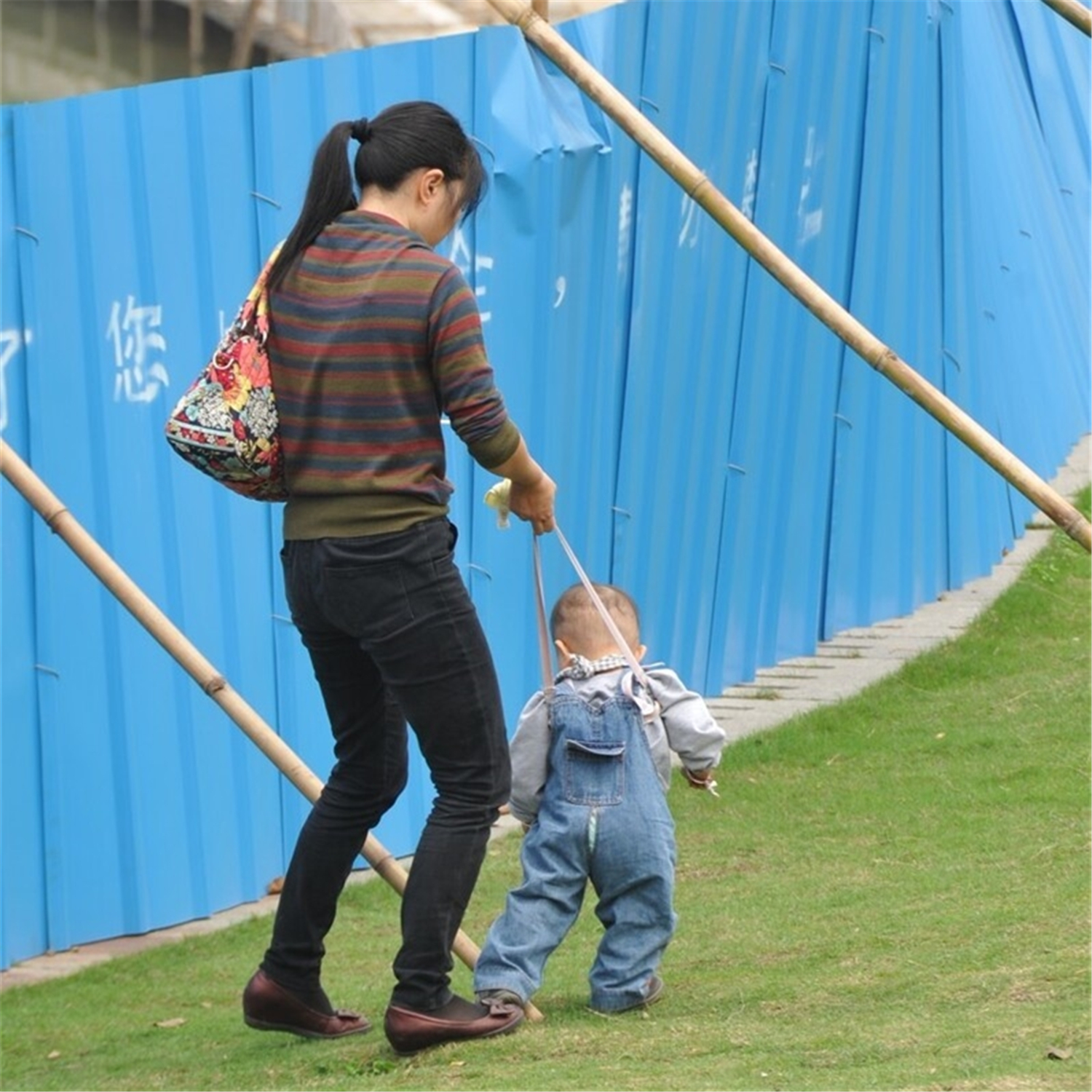 牵着宝宝的一只手学走路,牵着宝宝学走路的带子