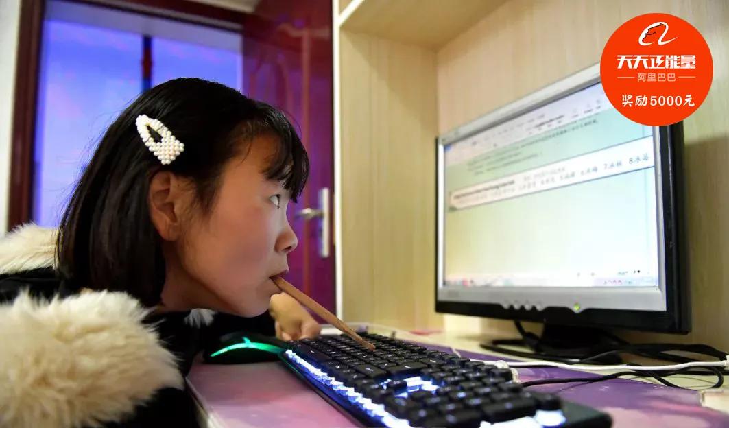 残疾女孩用嘴叼木棍写字,残疾女孩嘴叼木棍