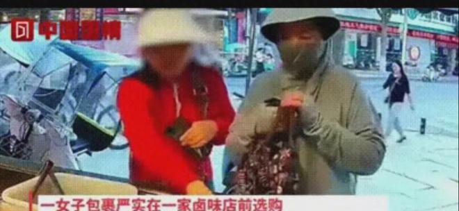 女人趁老板不注意偷偷把红烧马德利塞进包里，旁边的顾客一脸愕然